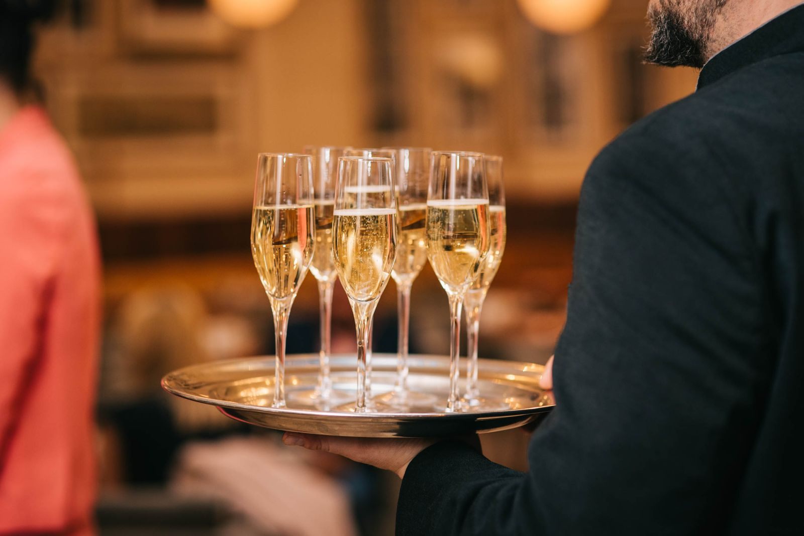 Waiter carrying a tray of champagne glasses at a celebration